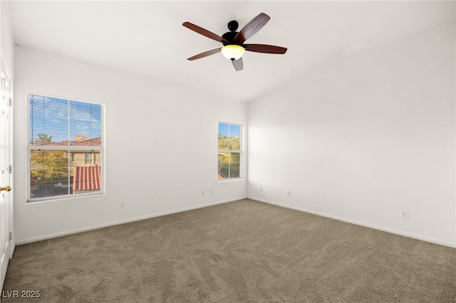 carpeted empty room with baseboards, a ceiling fan, and vaulted ceiling