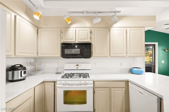 kitchen featuring white appliances, light countertops, and a peninsula