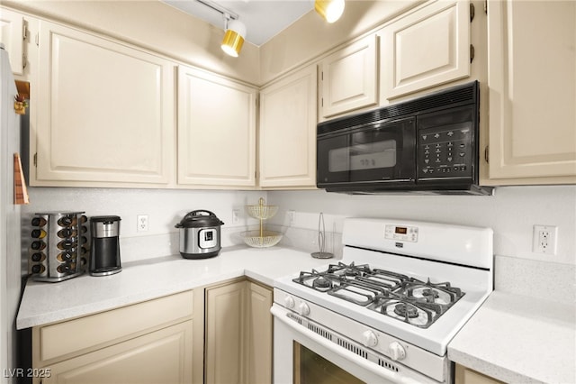 kitchen with light countertops, white range with gas stovetop, black microwave, and track lighting