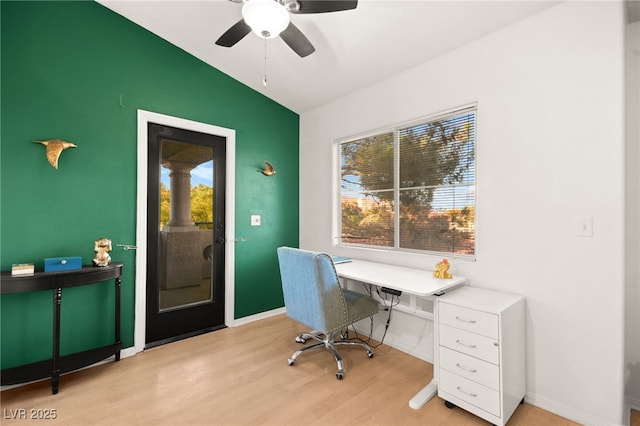 office space featuring vaulted ceiling, baseboards, and light wood finished floors