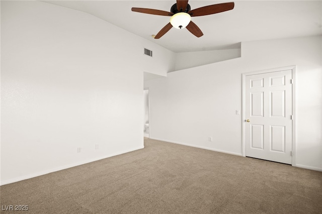 carpeted spare room with visible vents, lofted ceiling, baseboards, and ceiling fan