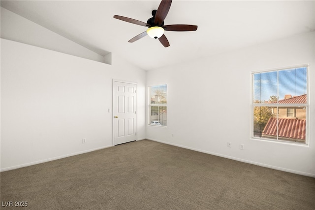 carpeted empty room with lofted ceiling, baseboards, and ceiling fan