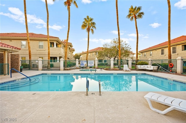 pool with a patio area, a residential view, and fence