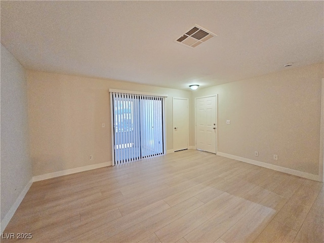 unfurnished room with visible vents, baseboards, and light wood-style floors