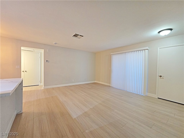 unfurnished room with visible vents, baseboards, and light wood-style flooring