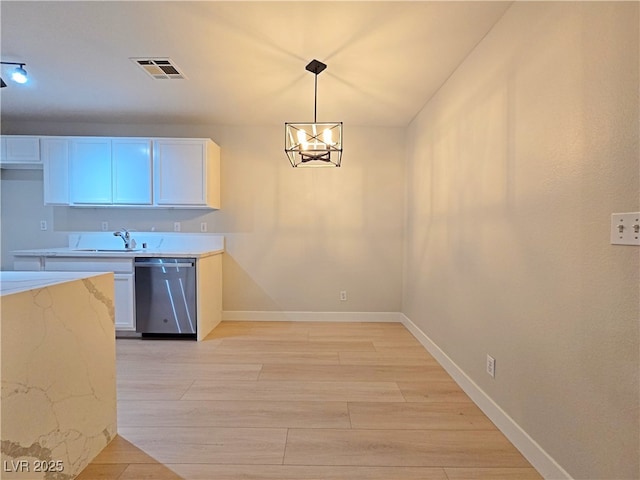 kitchen with visible vents, light wood-style flooring, a sink, light stone countertops, and dishwasher