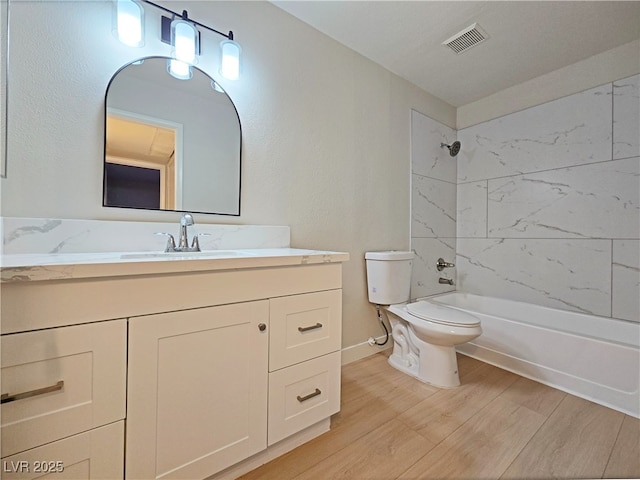 bathroom with visible vents, toilet, shower / bath combination, wood finished floors, and vanity