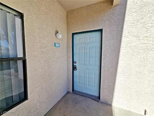 entrance to property featuring stucco siding