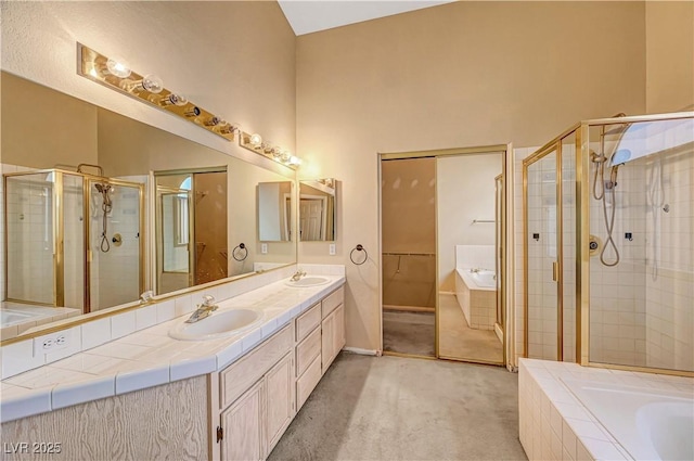 full bath featuring a sink, double vanity, a bath, and a shower stall