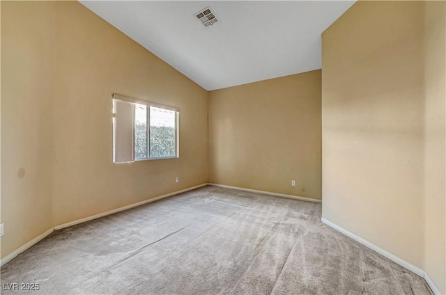 carpeted empty room featuring lofted ceiling, baseboards, and visible vents