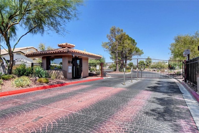 view of street featuring a gate, curbs, and a gated entry