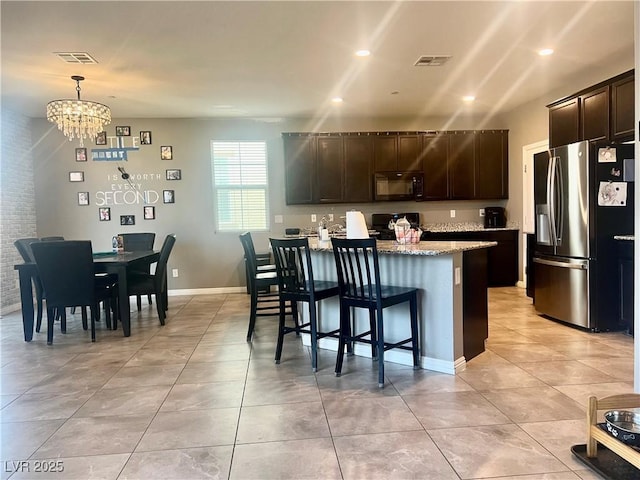 kitchen with visible vents, range, black microwave, and stainless steel fridge with ice dispenser