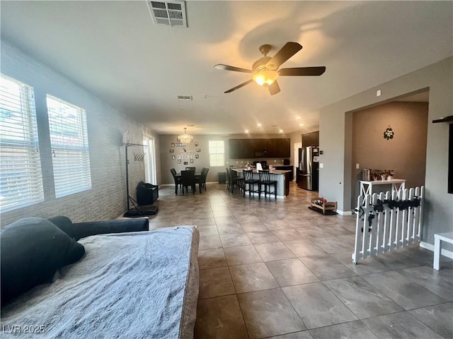 living room featuring visible vents, brick wall, an accent wall, tile patterned floors, and a ceiling fan