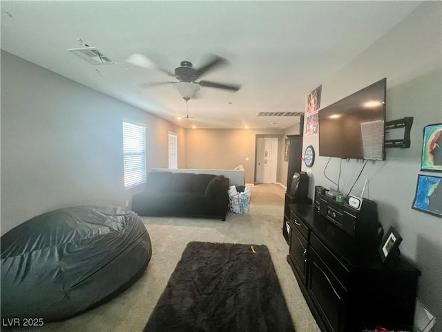 living room with visible vents, carpet flooring, and a ceiling fan