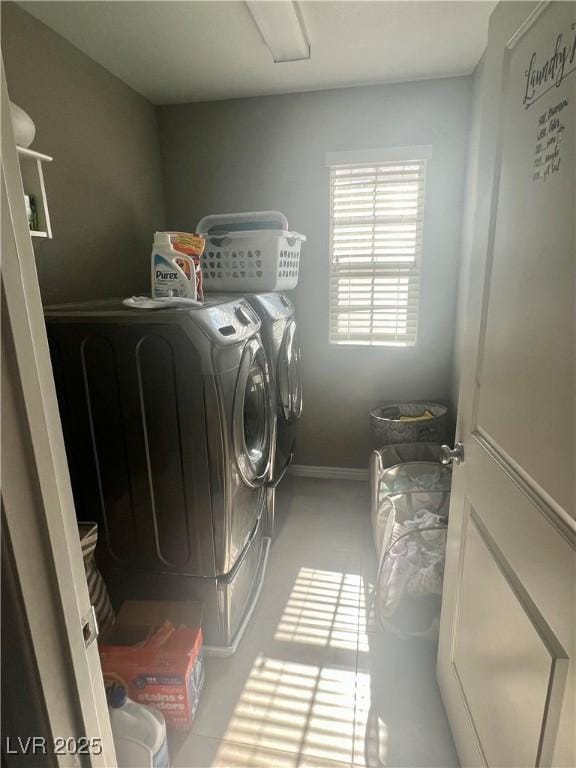 clothes washing area with washing machine and clothes dryer, laundry area, and baseboards