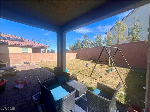 view of patio / terrace with an outdoor living space, a fenced backyard, and a playground