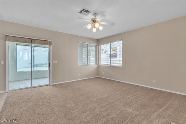 empty room with visible vents, baseboards, light colored carpet, and a ceiling fan