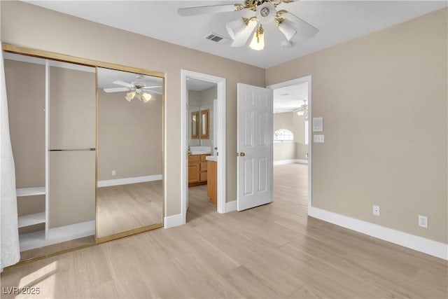 unfurnished bedroom with a ceiling fan, visible vents, baseboards, light wood-style floors, and a closet