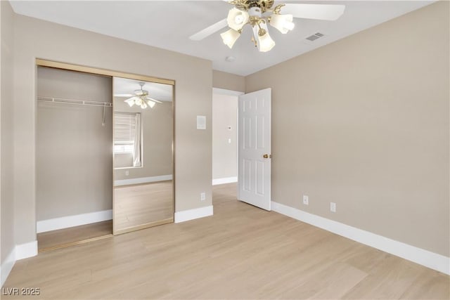 unfurnished bedroom with a closet, visible vents, light wood-style flooring, and baseboards