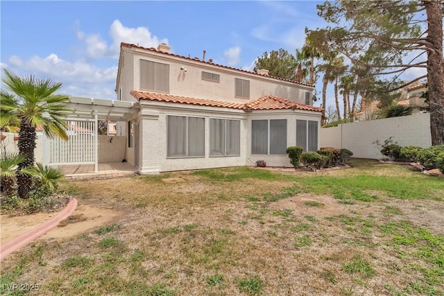 rear view of house featuring a tiled roof, stucco siding, a patio area, and fence