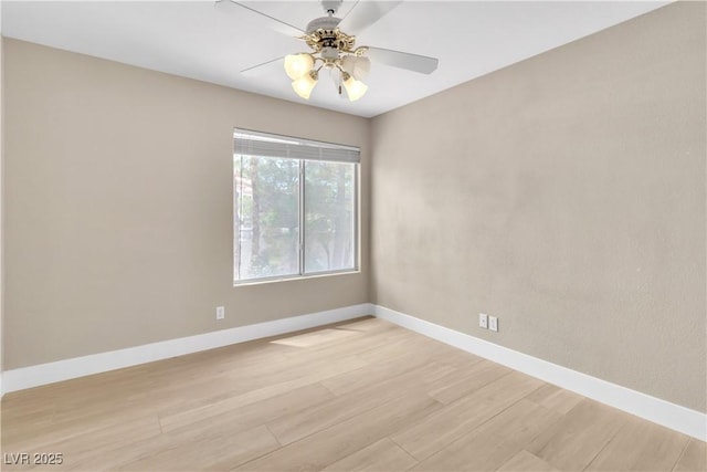 spare room with light wood-style flooring, a ceiling fan, and baseboards