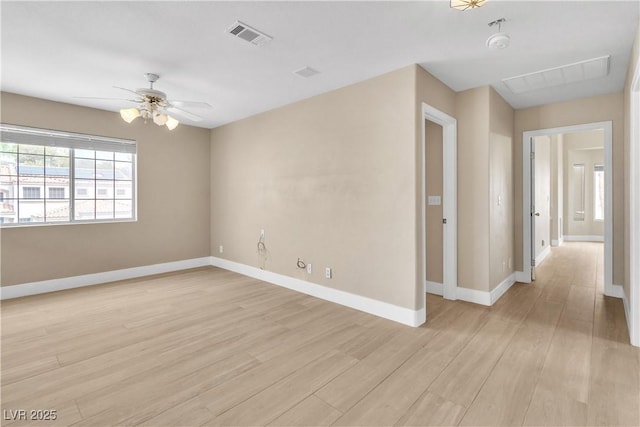 empty room with visible vents, baseboards, light wood-style floors, and a ceiling fan