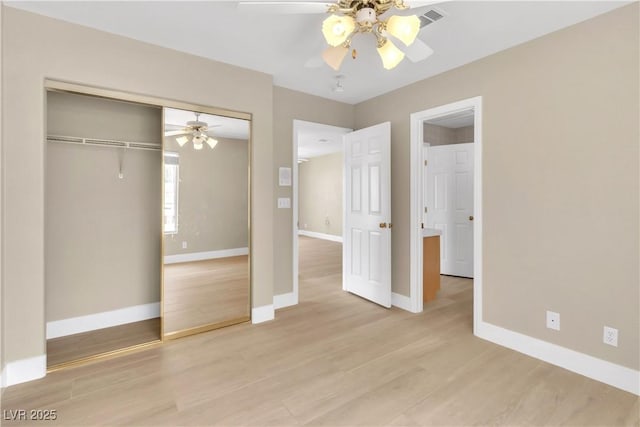 unfurnished bedroom with light wood finished floors, baseboards, a closet, and a ceiling fan