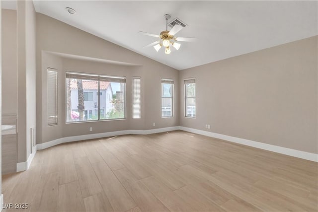 empty room featuring visible vents, baseboards, ceiling fan, lofted ceiling, and light wood-style flooring