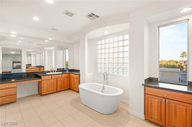 bathroom with recessed lighting, visible vents, a freestanding bath, and vanity