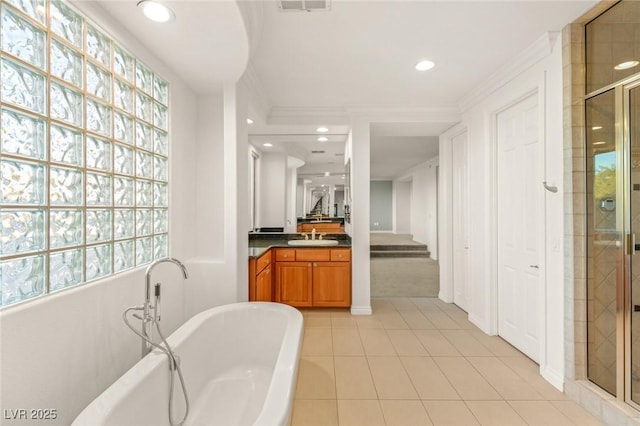 bathroom with recessed lighting, vanity, a soaking tub, and a shower stall