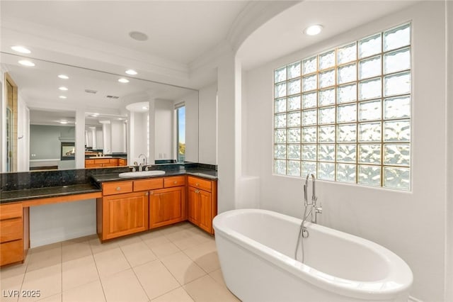 full bath featuring a soaking tub, recessed lighting, vanity, and crown molding