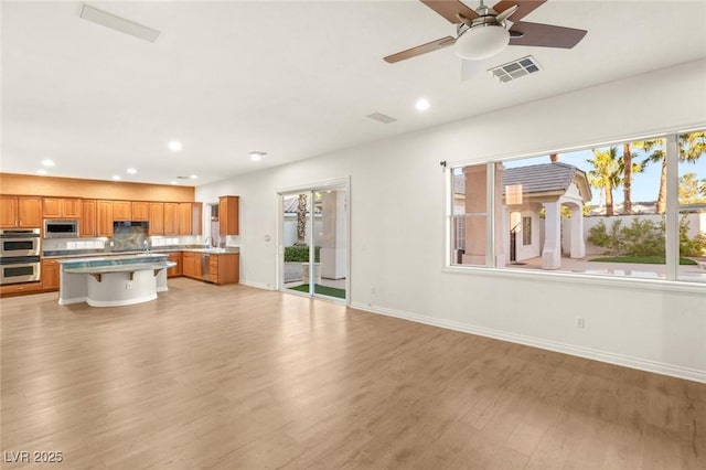 kitchen featuring visible vents, stainless steel appliances, light wood-type flooring, and light countertops