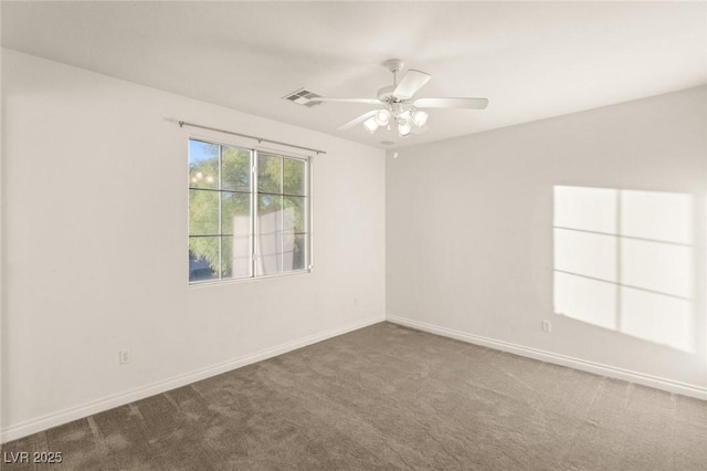 carpeted spare room with visible vents, a ceiling fan, and baseboards