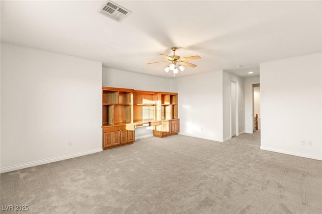 unfurnished living room with visible vents, built in study area, ceiling fan, and carpet floors