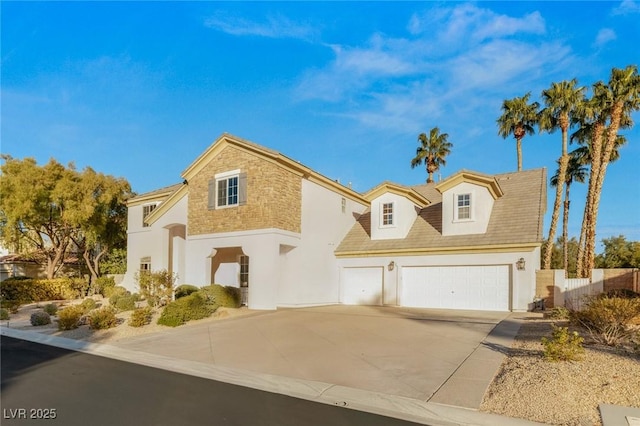 view of front of home featuring an attached garage, fence, driveway, and stucco siding