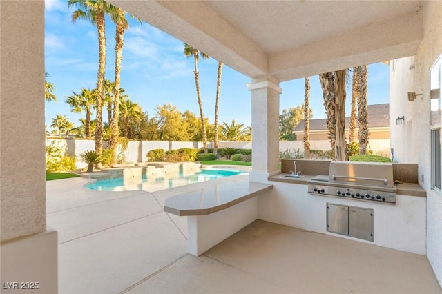 view of patio / terrace featuring a fenced backyard, a fenced in pool, a grill, and exterior kitchen