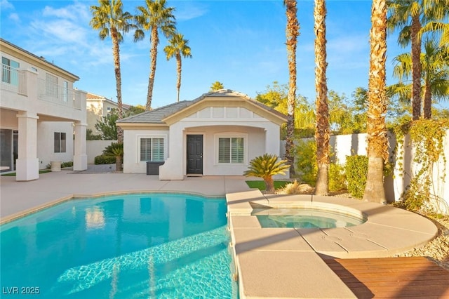 back of house with an outbuilding, a fenced backyard, an exterior structure, an in ground hot tub, and a patio area