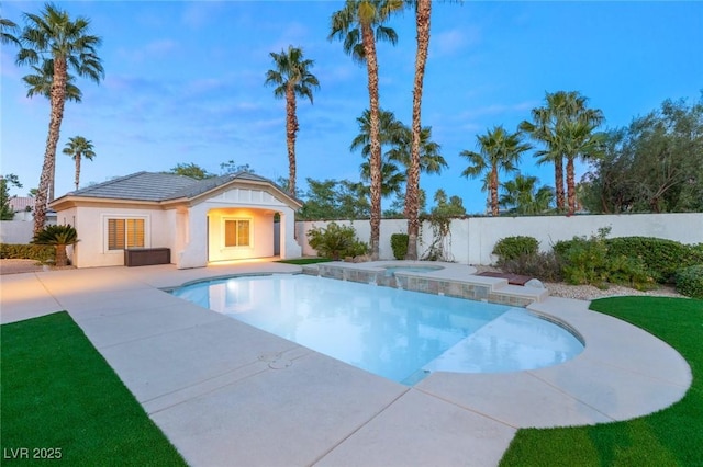 view of swimming pool with a fenced in pool, fence, a patio area, an in ground hot tub, and an outbuilding