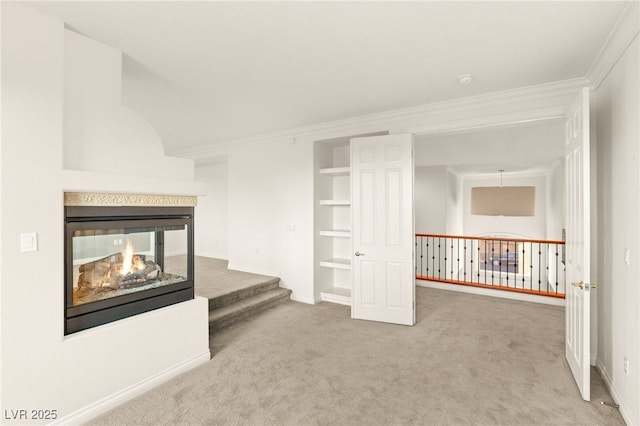 interior space featuring a multi sided fireplace, carpet flooring, baseboards, and ornamental molding