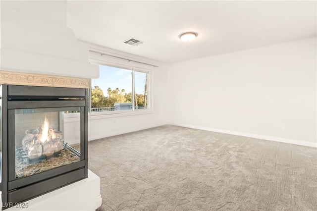 carpeted living room featuring visible vents, a multi sided fireplace, and baseboards