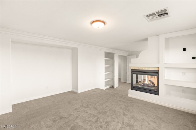 unfurnished living room with visible vents, built in shelves, carpet, and a multi sided fireplace