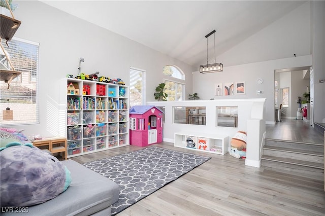 rec room with vaulted ceiling and wood finished floors