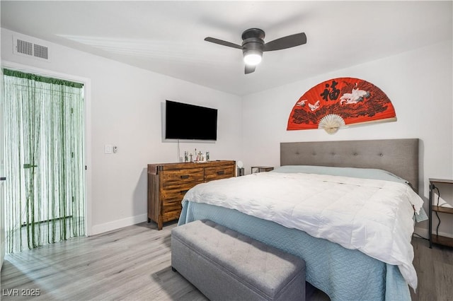 bedroom featuring ceiling fan, wood finished floors, visible vents, and baseboards