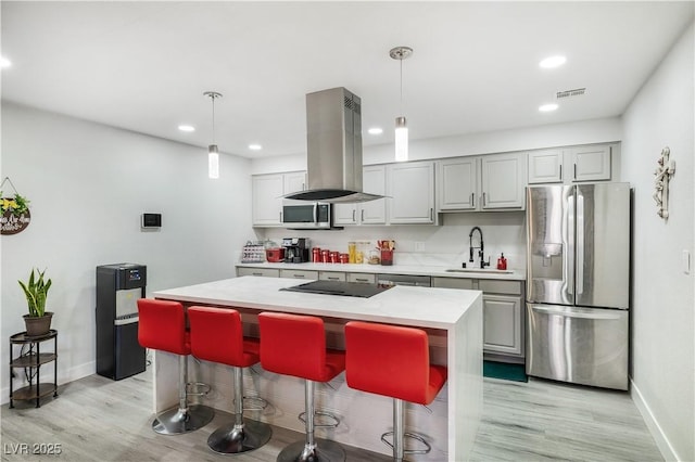 kitchen featuring visible vents, light countertops, island range hood, stainless steel appliances, and a sink