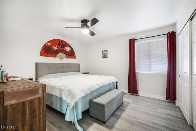 bedroom with ceiling fan, a closet, baseboards, and wood finished floors