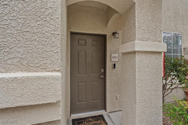 view of exterior entry with stucco siding