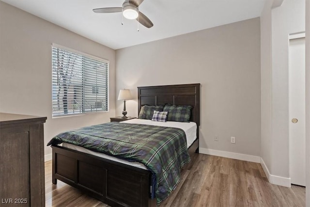 bedroom with wood finished floors, baseboards, and ceiling fan