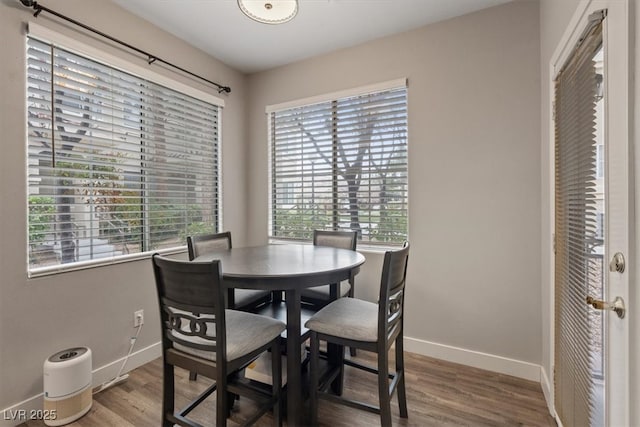 dining space with baseboards and wood finished floors