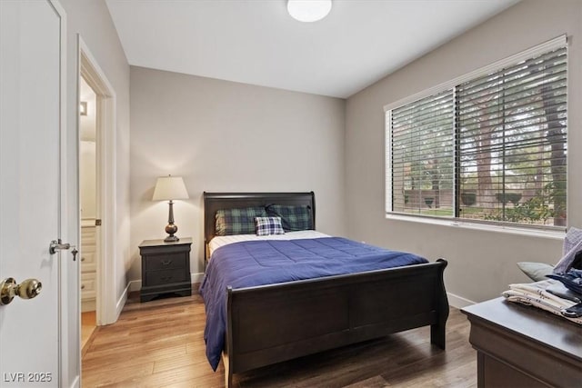 bedroom with light wood-style flooring and baseboards