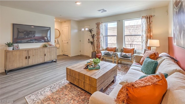 living area featuring recessed lighting, visible vents, baseboards, and light wood-style flooring